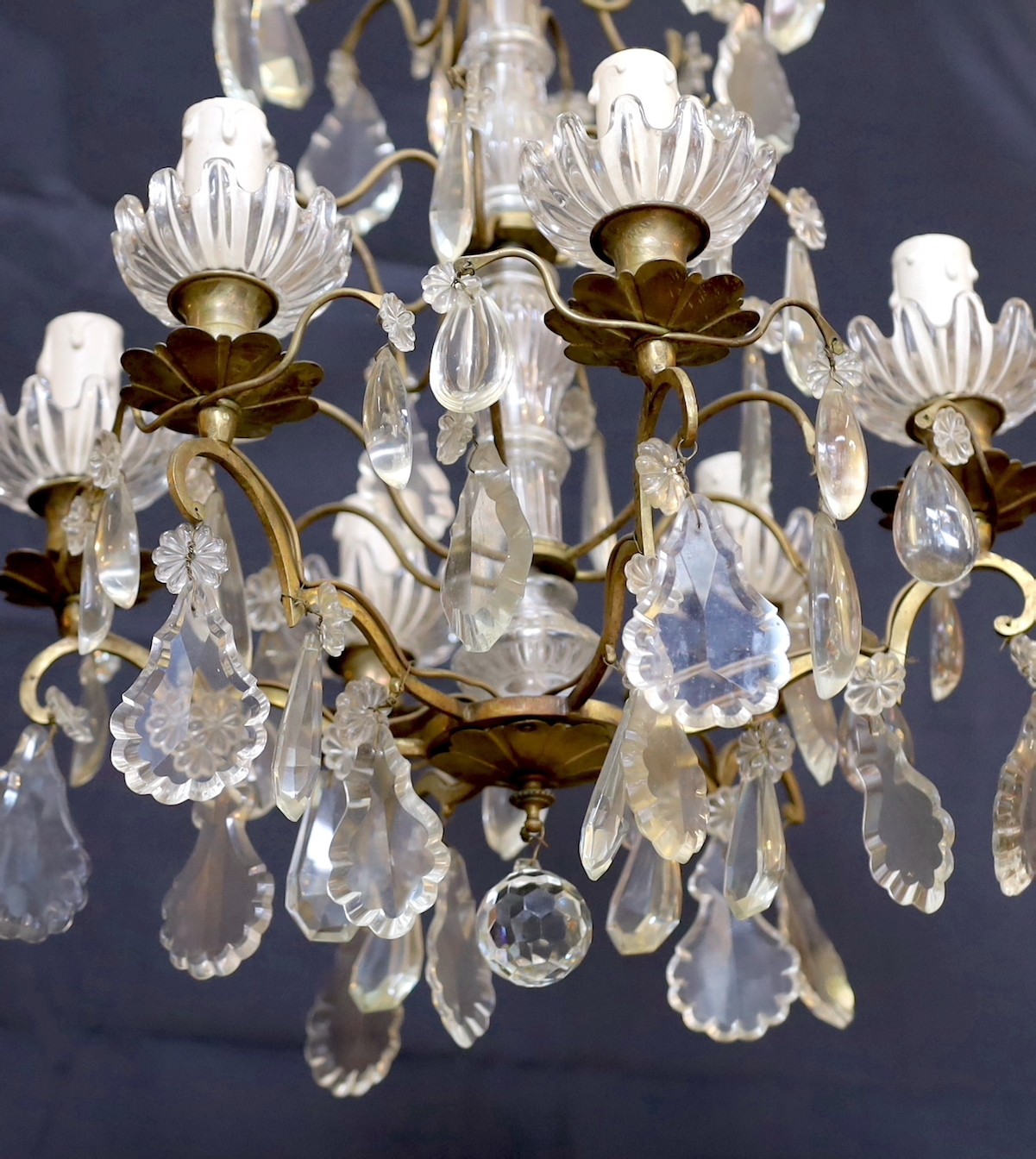 An early 20th century French bronze and cut glass six light chandelier hung with tear and lozenge shaped drops, drop 50cm. width 35cm